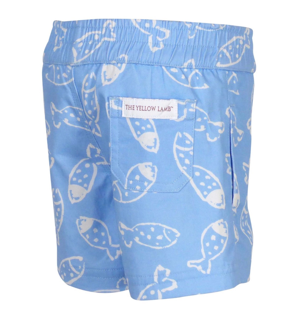 Blue shorts with white fish pattern and 'The Yellow Lamb' label on a white background