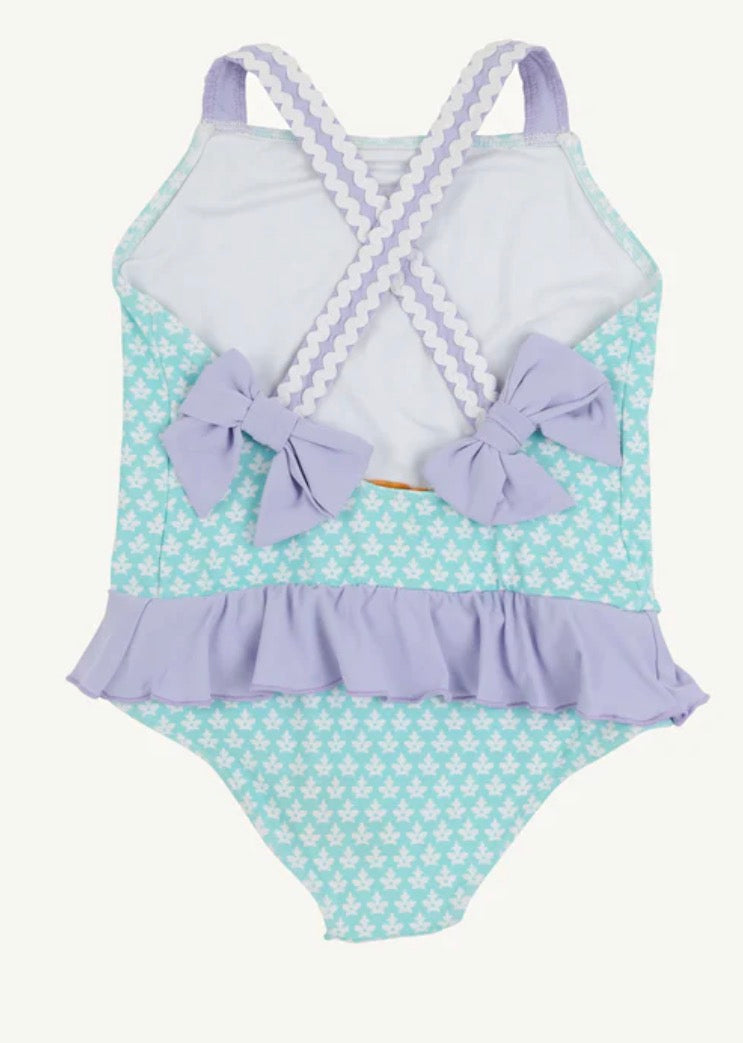 Children's swimsuit with polka dot pattern and purple accents on a white background