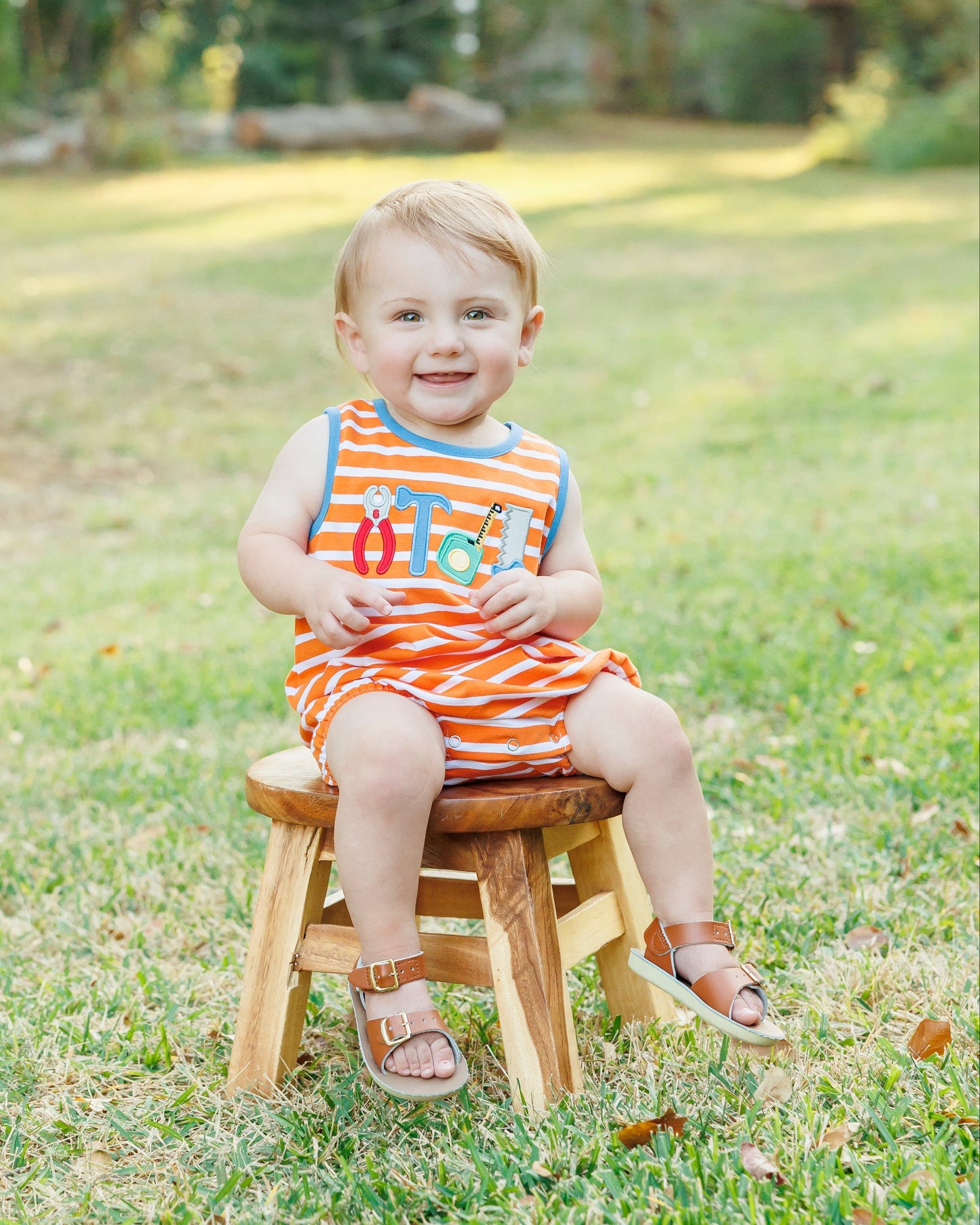 Young boy wearing orange striped tool applique bubble.