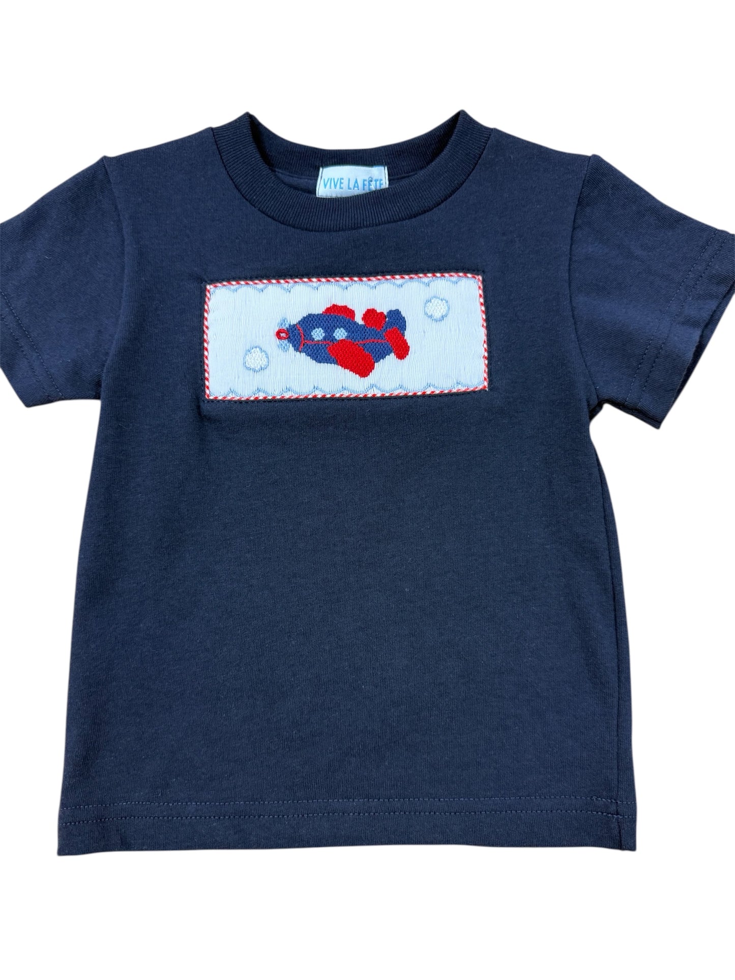 Navy blue smocked shirt with a colorful airplane design on a white background
