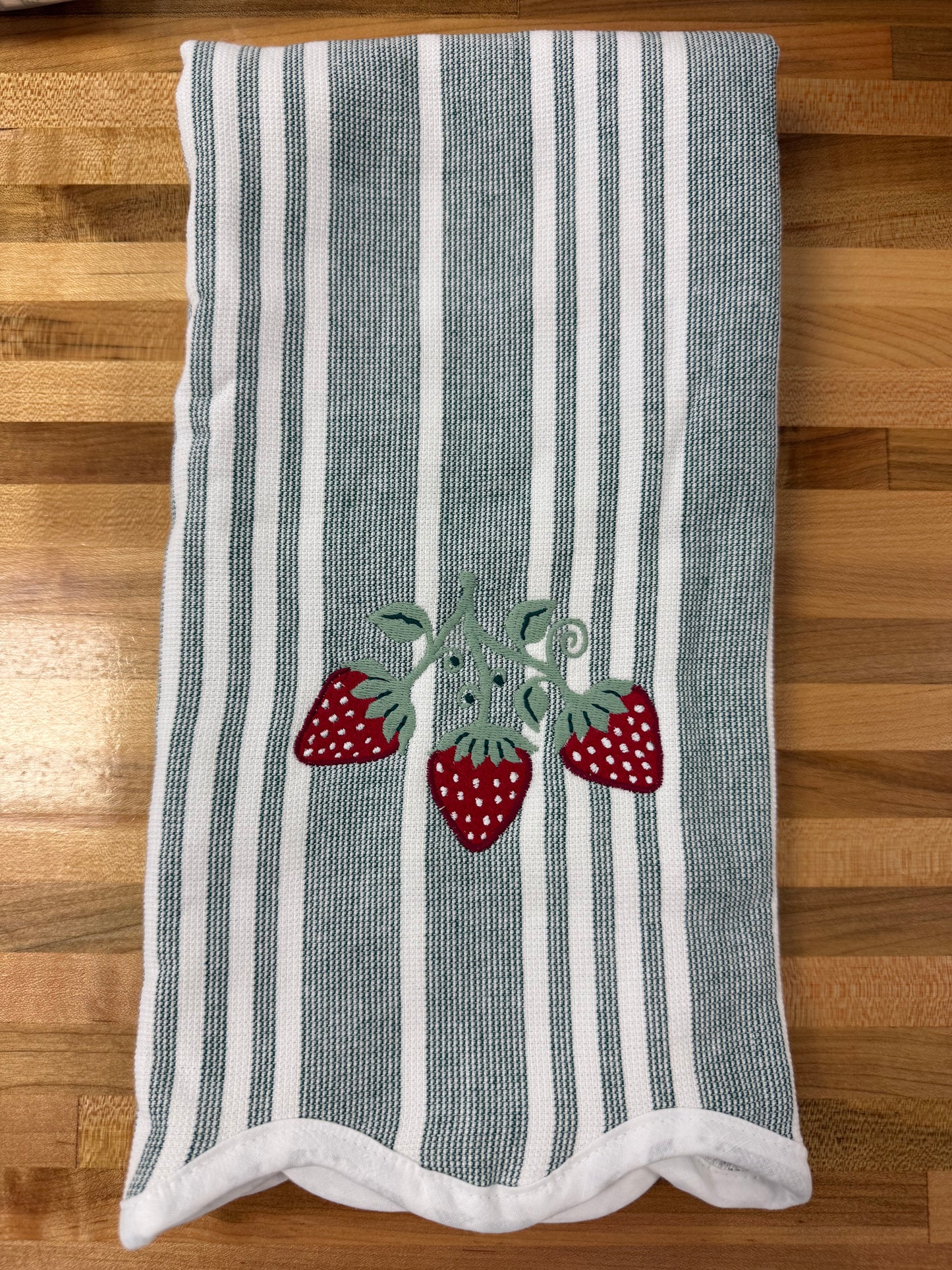 Striped towel with strawberry design on a wooden surface