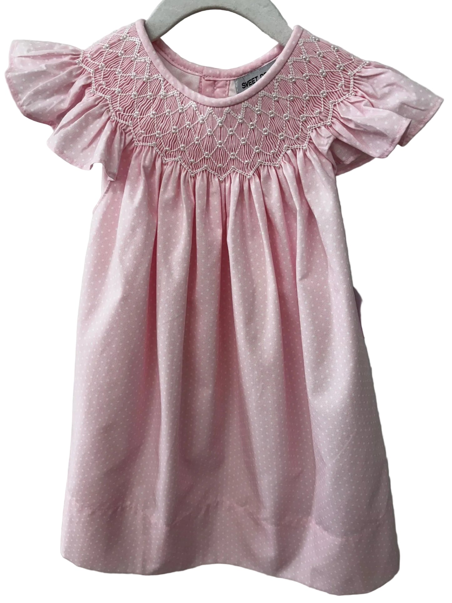 Pink polka dot dress with ruffle sleeves and pearl embellished smocking.