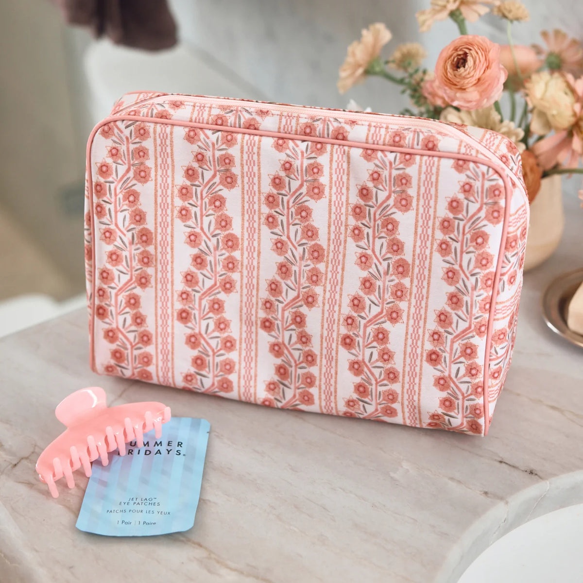 A rectangular cosmetic pouch with a pink and white floral vertical stripe pattern