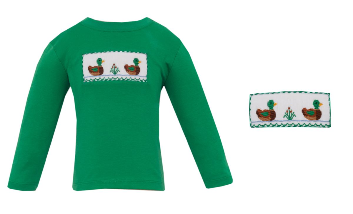 A green long-sleeve baby/toddler top with a rectangular smocked chest patch featuring three ducks and small plants, shown on a white background with a smaller inset of the patch detail.