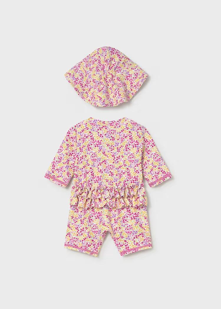 Ruffle detail on back of pink and yellow floral swimsuit and hat set.