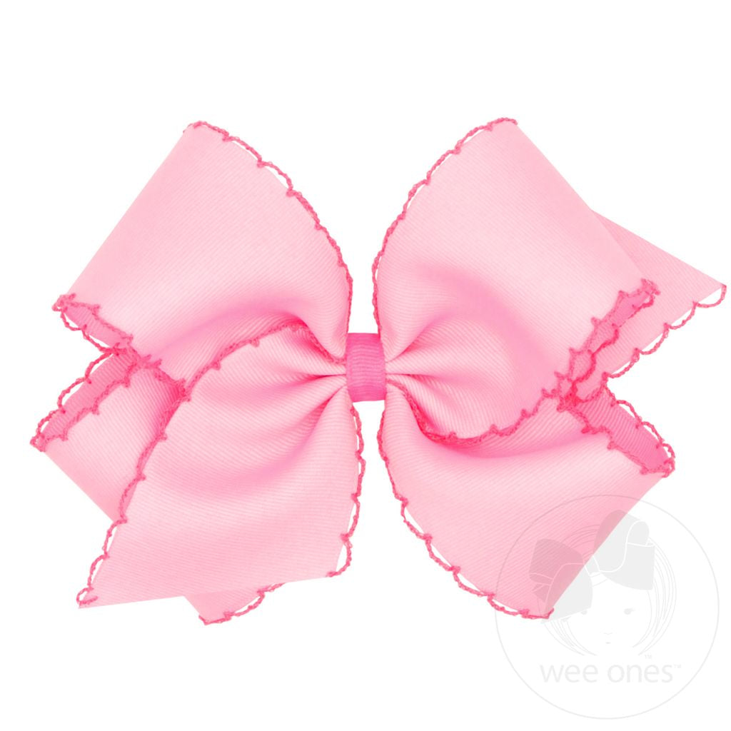 Pink hair bow with a moonstitch edge.