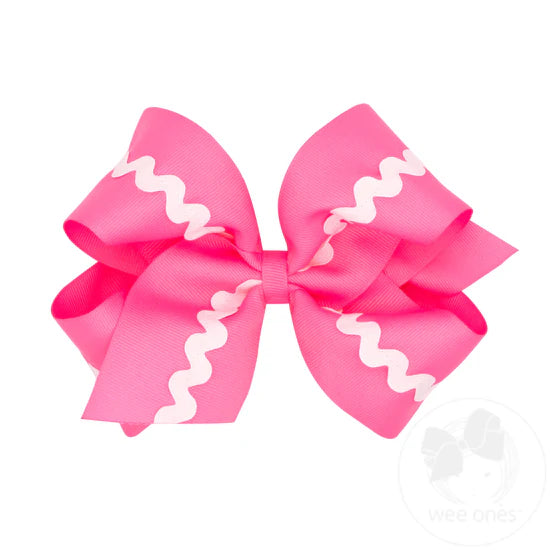Bright pink hair bow with white ric rac trim.