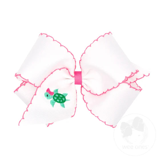 White hair bow with pink moonstitch edging and embroidered turtle.