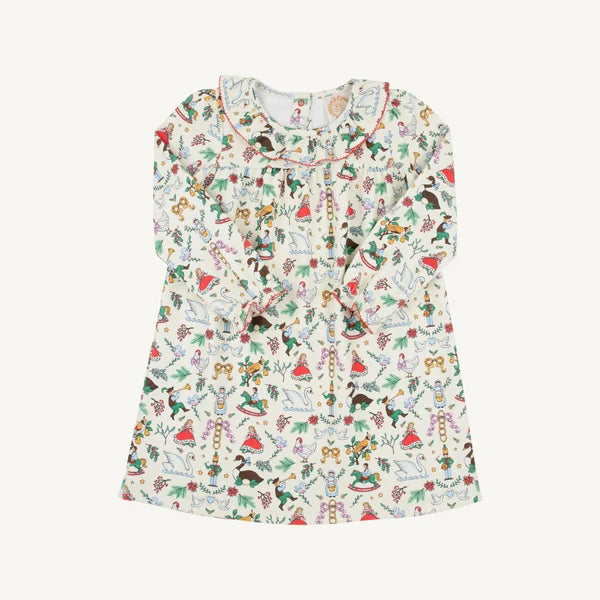 A long-sleeve baby dress with a ruffled neckline and an all-over whimsical print of fairies, elves, and holiday motifs of 12 days of christmas 