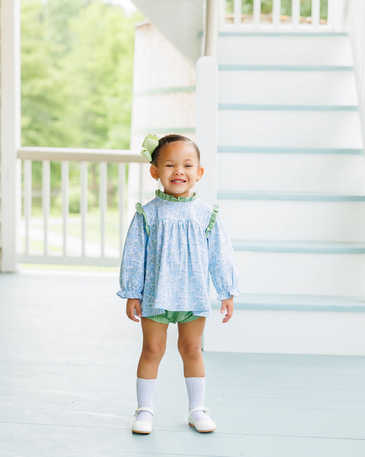 Blue and green floral diaper set with ruffles around neck and shoulder