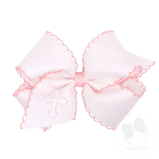 White hair bow with embroidered cross and pink moonstitch edging.