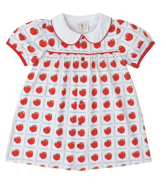 White dress with red apples inside a blue pencil check pattern, with red piping around the collar and short sleeves.