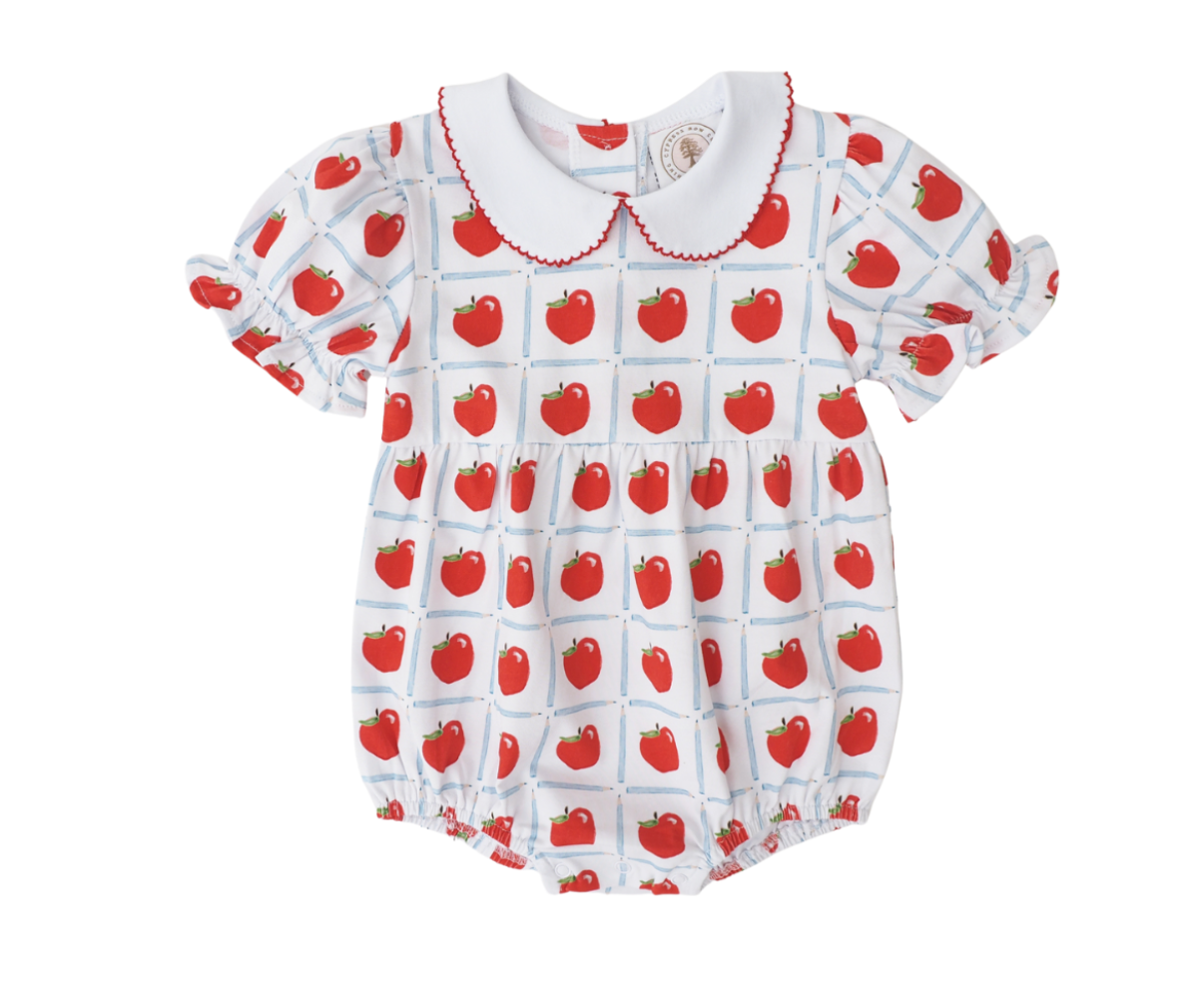 White bubble with red apples inside a blue pencil check pattern, with red scalloped piping around the collar and puffed short sleeves.
