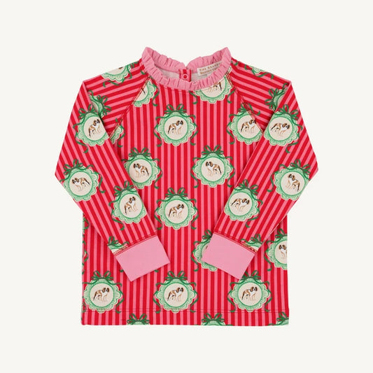 A long-sleeve children's top featuring a red and white vertical stripe pattern, decorated with green and pink dog motifs. It has a pink ruffled collar and solid pink cuffs.