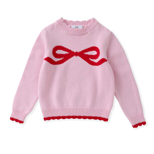 A light pink knit sweater with a red knitted bow motif across the chest and a matching red scalloped trim at the hem and cuffs, shown on a plain white background.