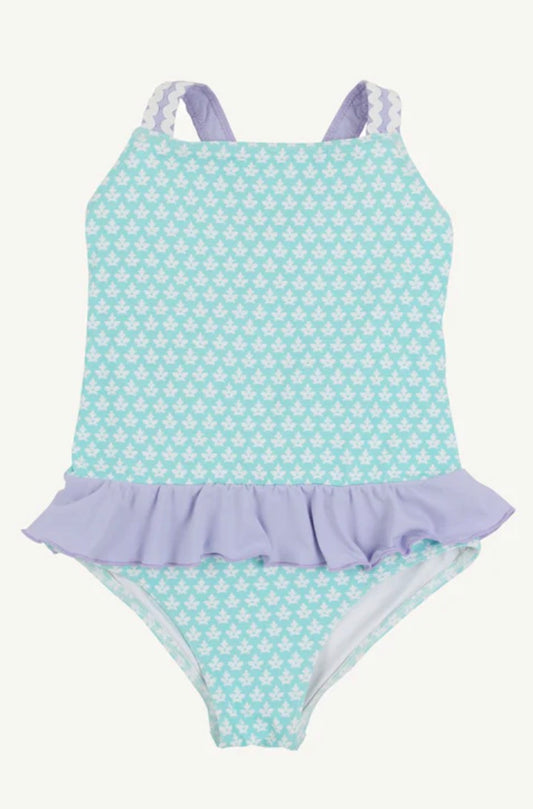Children's swimsuit with blue and white pattern and purple ruffle on a white background