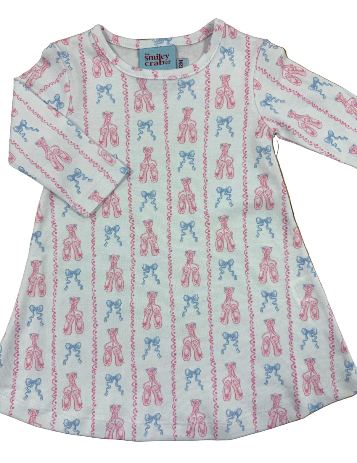 A long-sleeve baby dress  featuring an all-over ballet pointe pattern in pink and blue on a white background.