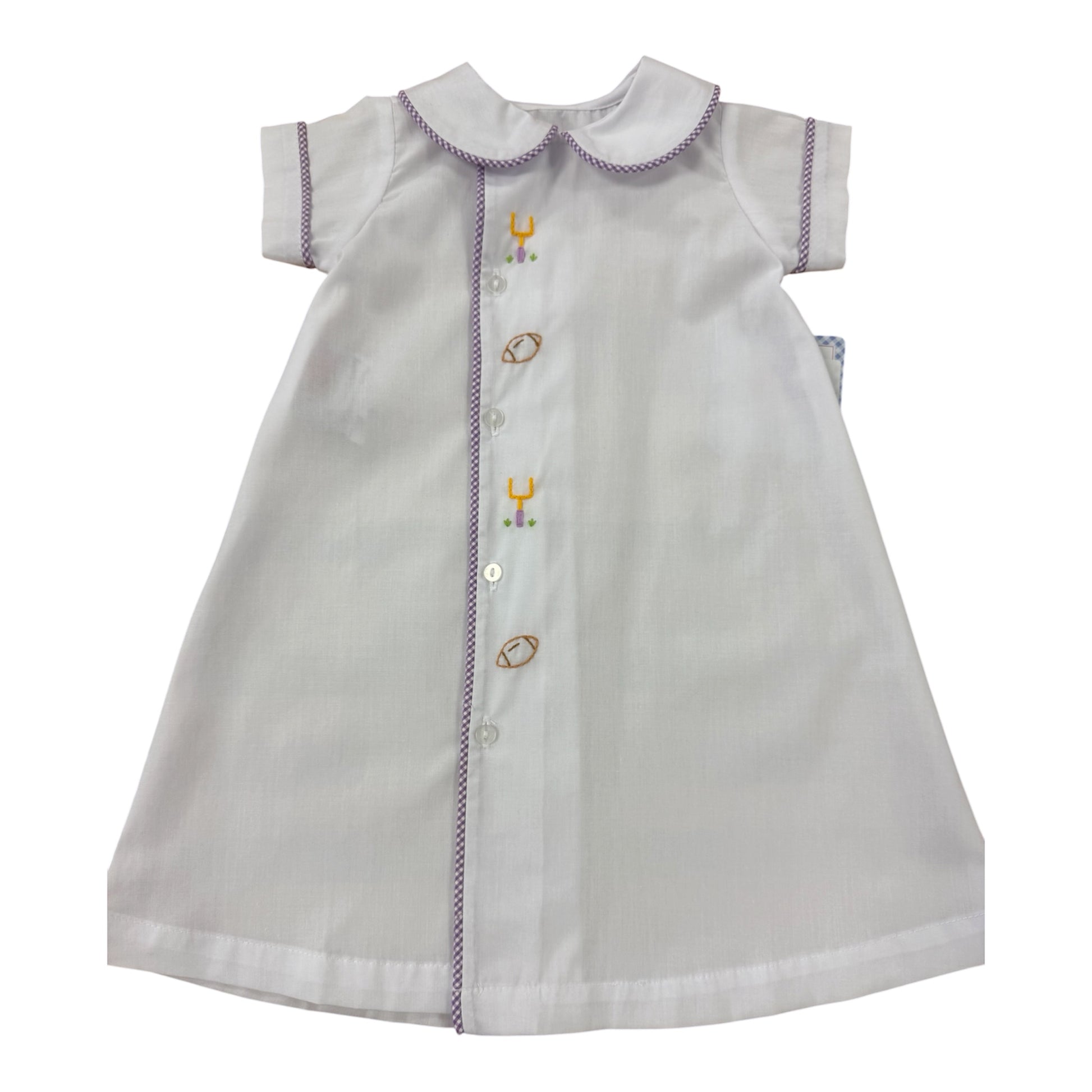White baby dress with embroidered yellow and purple football details on a white background
