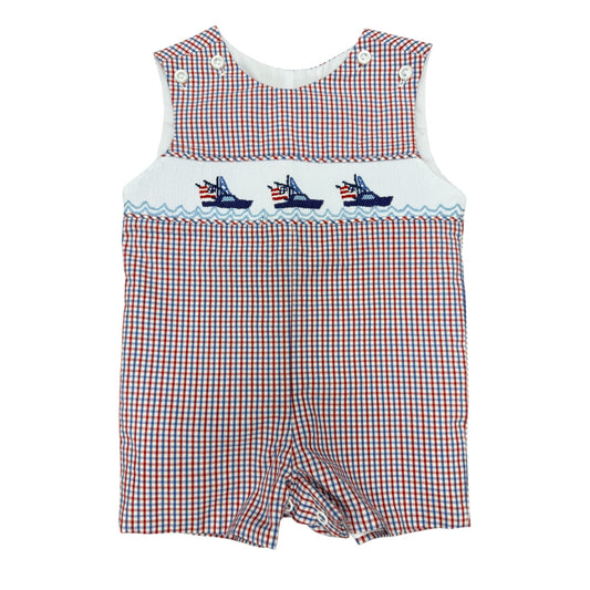 Red, white, and blue checkered smocked baby boy romper with embroidered boats on a white background