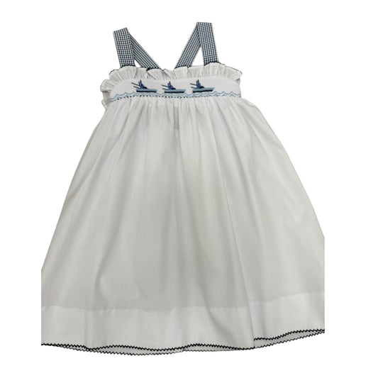 White smocked dress with navy checkered straps with boats on the chest.
