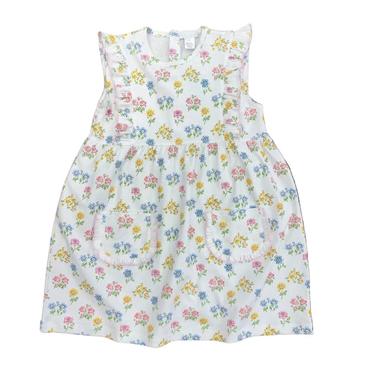 Pink, yellow and blue flowers on a white dress with ruffled patch pockets.