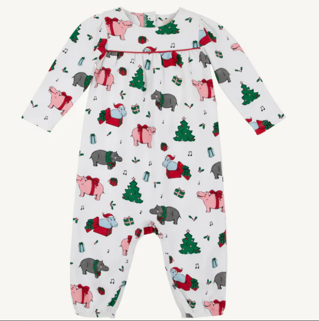 White long sleeve playsuit with red trim and a Christmas pattern with trees and hippos.