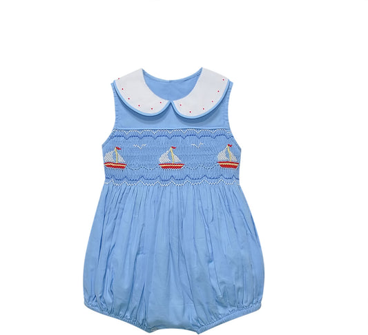 Light blue smocked bubble with a white embellished collar and embroidered sailboats.