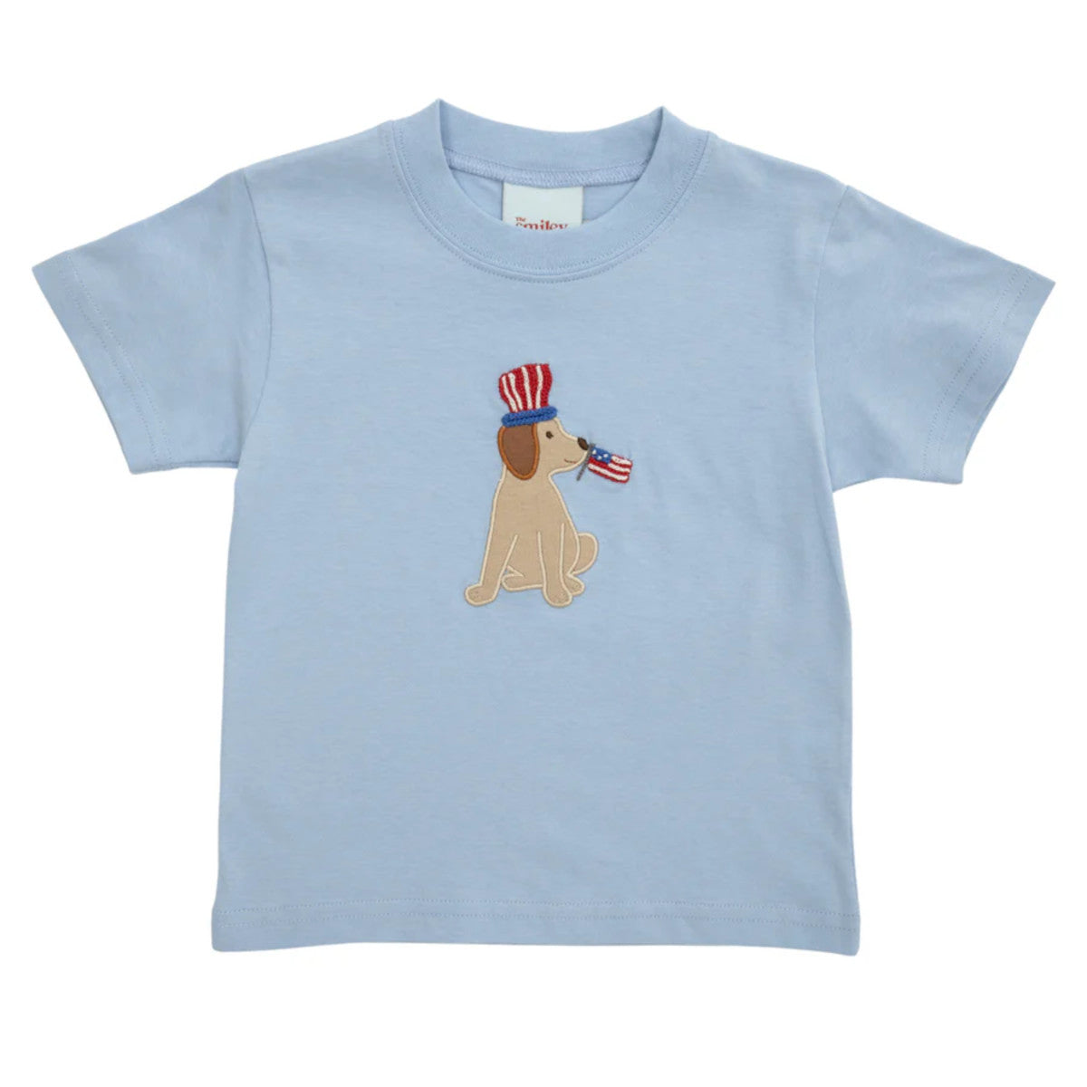 Light blue t-shirt with a dog wearing an American flag hat and holding a flag in its mouth.