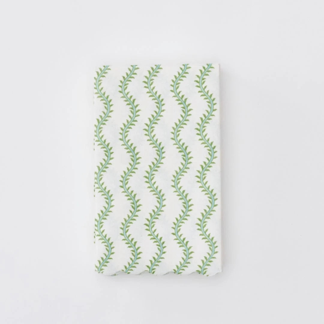 A folded white fabric item, linen napkin featuring a repeating vertical pattern of green leafy vines, shown against a plain white background.