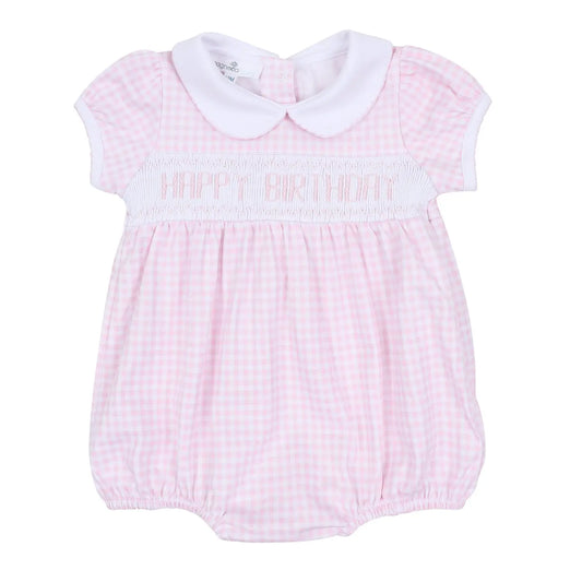 Pink checkered smocked baby romper with 'Happy Birthday' text on a white background