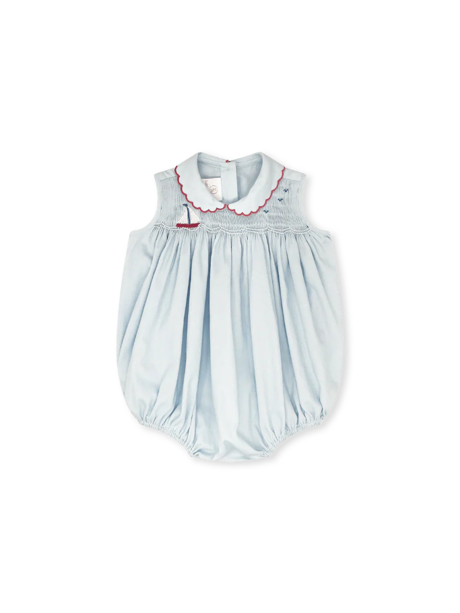 Light blue smockec baby romper with red trim and sailboat design