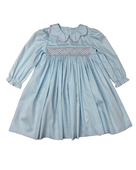 A light blue long-sleeve baby dress with smocked detailing across the chest and a scalloped Peter Pan collar, shown flat against a white background.