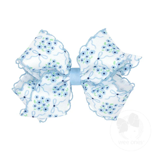 Blue flower print and moonstitch edge on white hair bow.