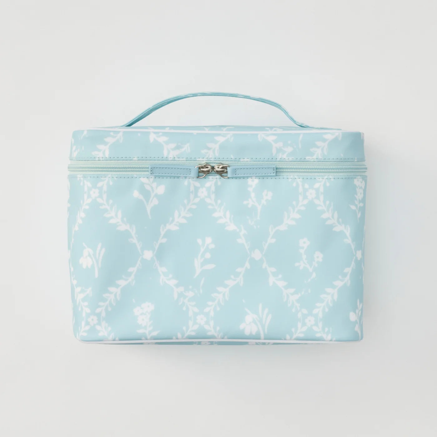 A light blue cosmetic bag with a white floral trellis pattern, featuring a top handle and a silver-tone bow detail on the zipper pull, set against a plain light gray background.