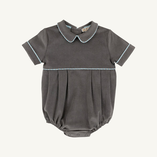 A dark gray baby romper with a pleated bodice, short sleeves, and a Peter Pan collar, featuring light blue piping details on the collar, sleeve cuffs, and a horizontal seam.