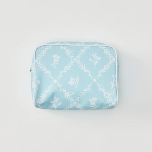 A light blue zippered pouch with a white floral and leafy trellis pattern, photographed flat against a clean white background.