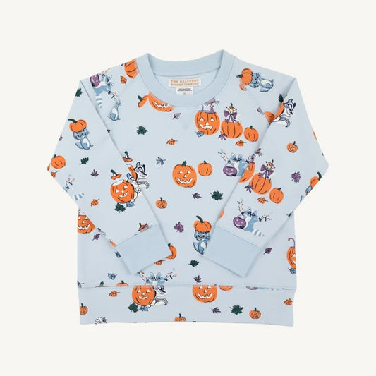 A light blue long-sleeve crewneck sweatshirt with an all-over Halloween print featuring orange pumpkins, ghosts, and spiderwebs, laid flat on a light cream background.
