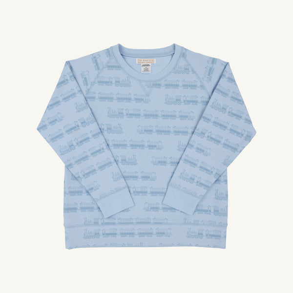 A light blue long-sleeve crewneck sweatshirt with an all-over tonal train pattern, laid flat against a light cream background.