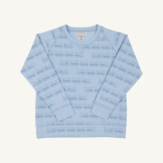 A light blue long-sleeve crewneck sweatshirt with an all-over tonal train pattern, laid flat against a light cream background.