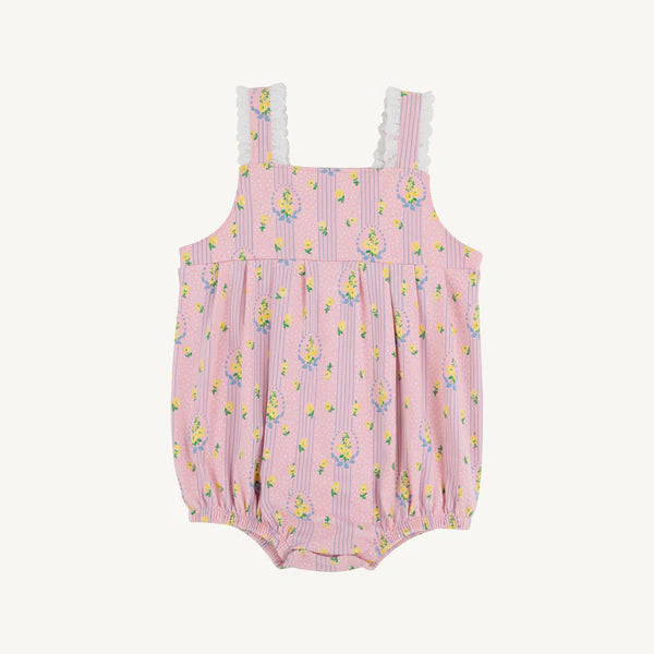 Pink romper with floral pink and yellow pattern and white eyelet trim on straps