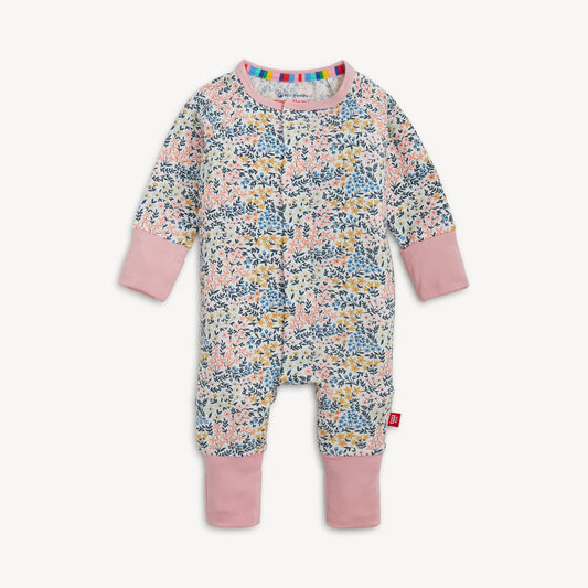 Baby coverall with pink cuffs and pastel floral pattern.