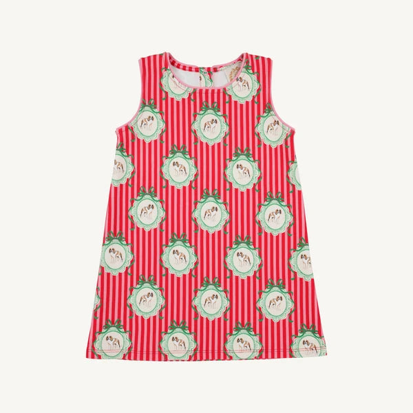 A sleeveless children's dress with a red and white vertical stripe pattern, decorated with repeating green and white dog medallion motifs, shown flat against a light off-white background.