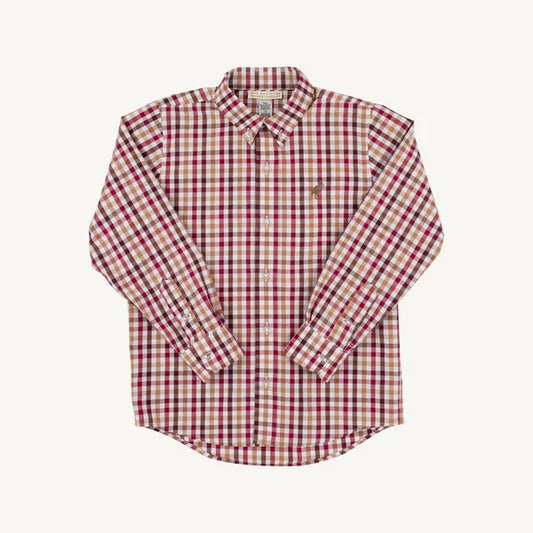 A long-sleeve button-down shirt with a red, beige, and tan gingham check pattern, featuring a small embroidered polo player logo on the left chest, laid flat against a light cream background.