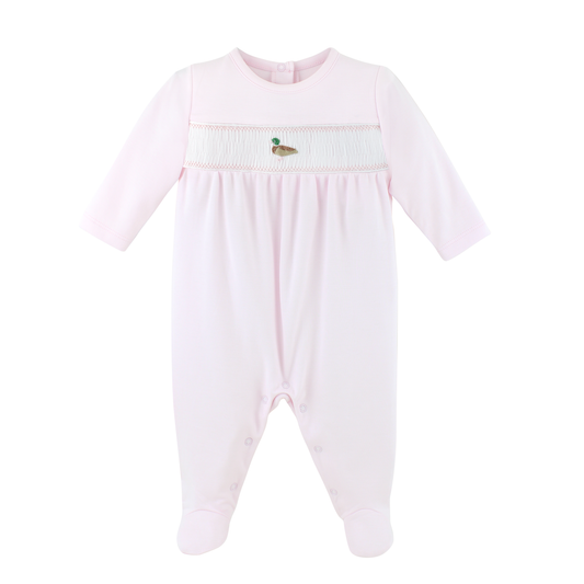 A light pink baby footed sleeper with long sleeves, a smocked chest panel, and a small duck embroidery at the center.