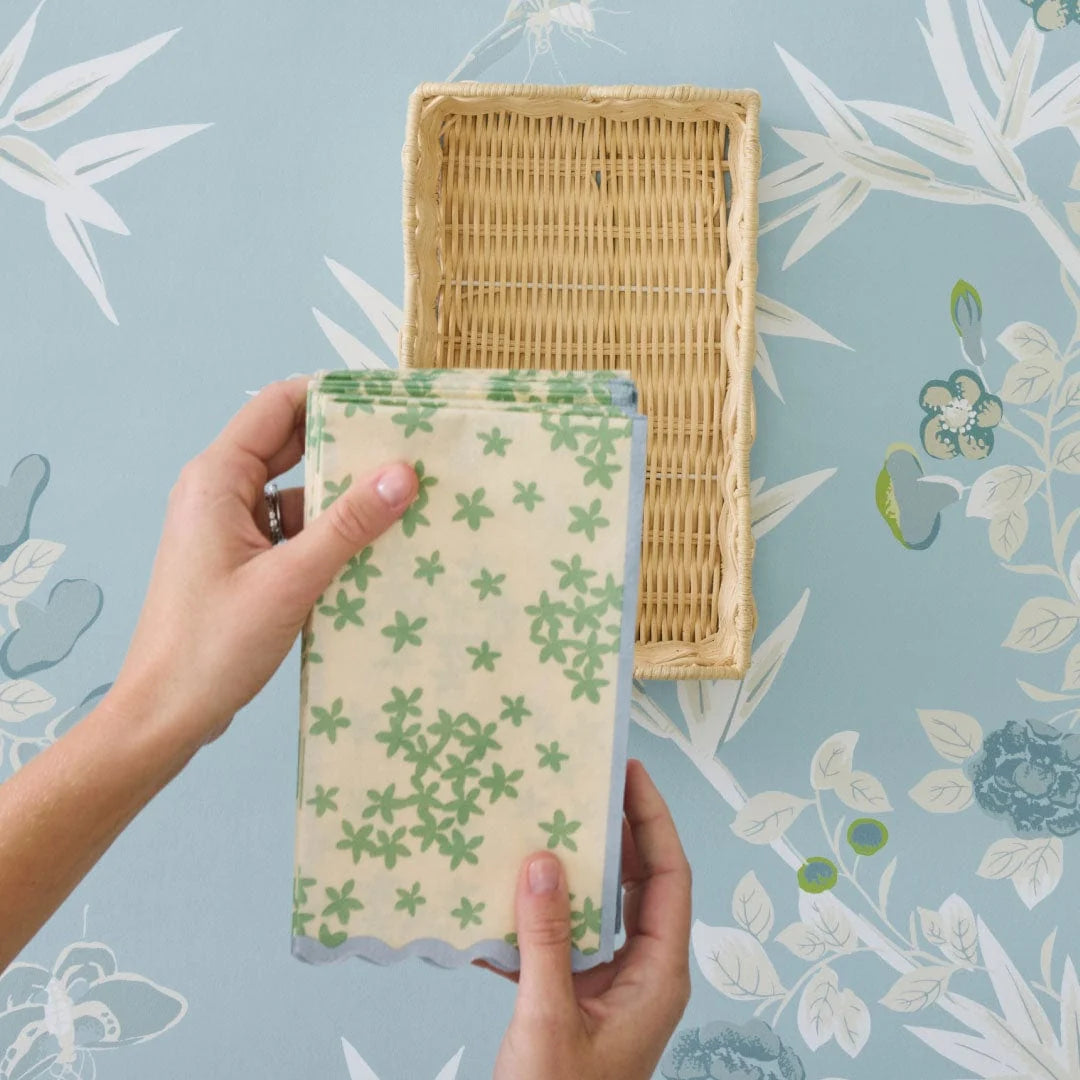 Cream colored napkin with green starts and blue scallop trim 