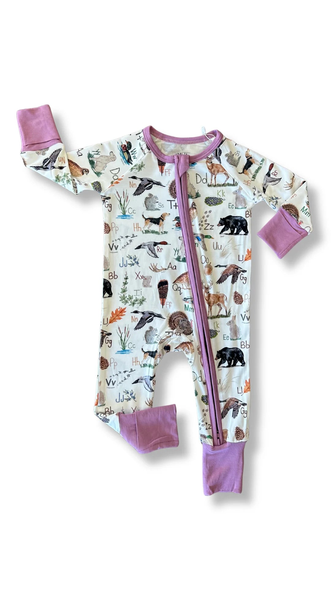 A baby's long-sleeve footed sleeper with a colorful animal and nature print on an off-white background, featuring solid purple cuffs, collar trim, and zipper.