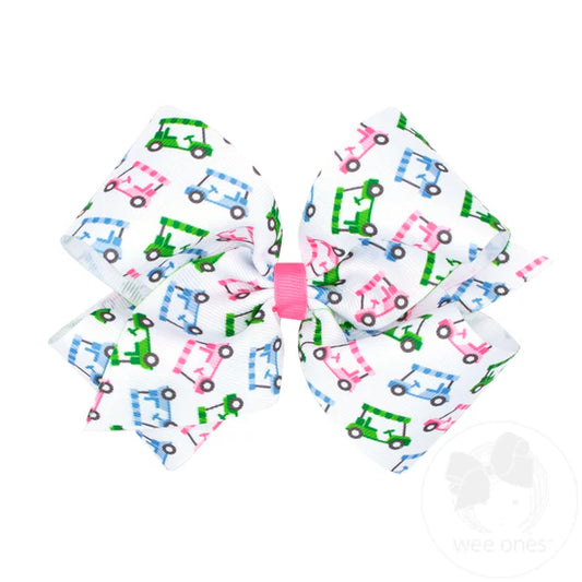 Pink, blue and green golf cart design on a white hair bow.