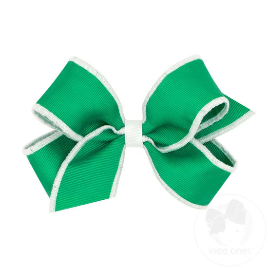 Green hair bow with cream serged edge.