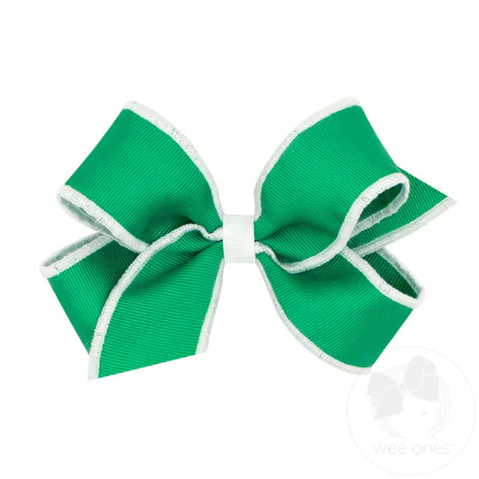 Green hair bow with cream serged edge.