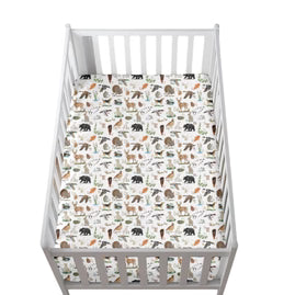 A white wooden crib shown from above, filled with a fitted sheet featuring a woodland safari animal print with bears, deer, and birds on a white background.